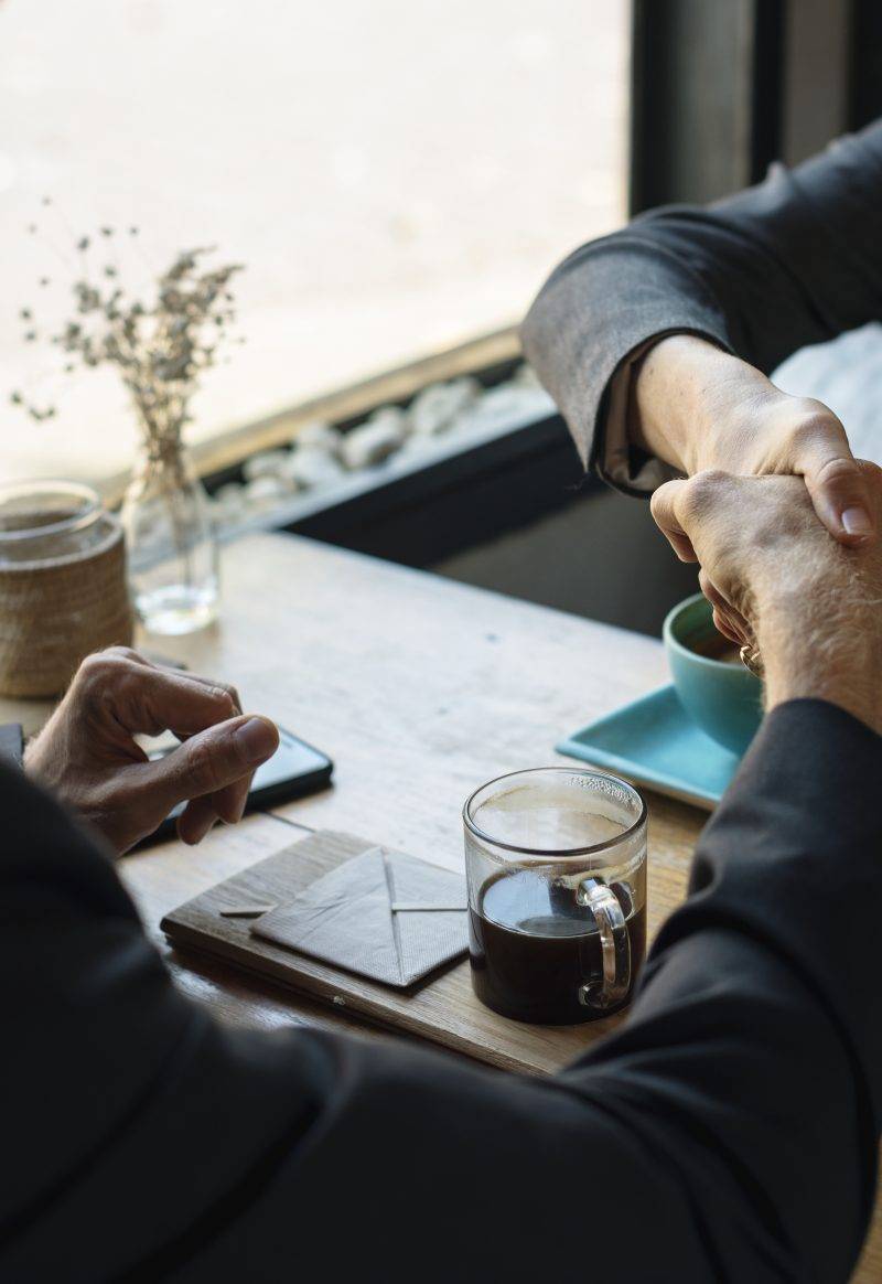 Business agreement handshake at coffee shop